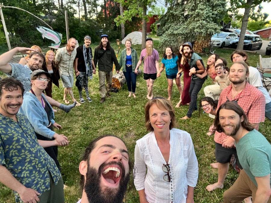 Scott West surrounded by a large group of friends and community members outdoors in Boulder