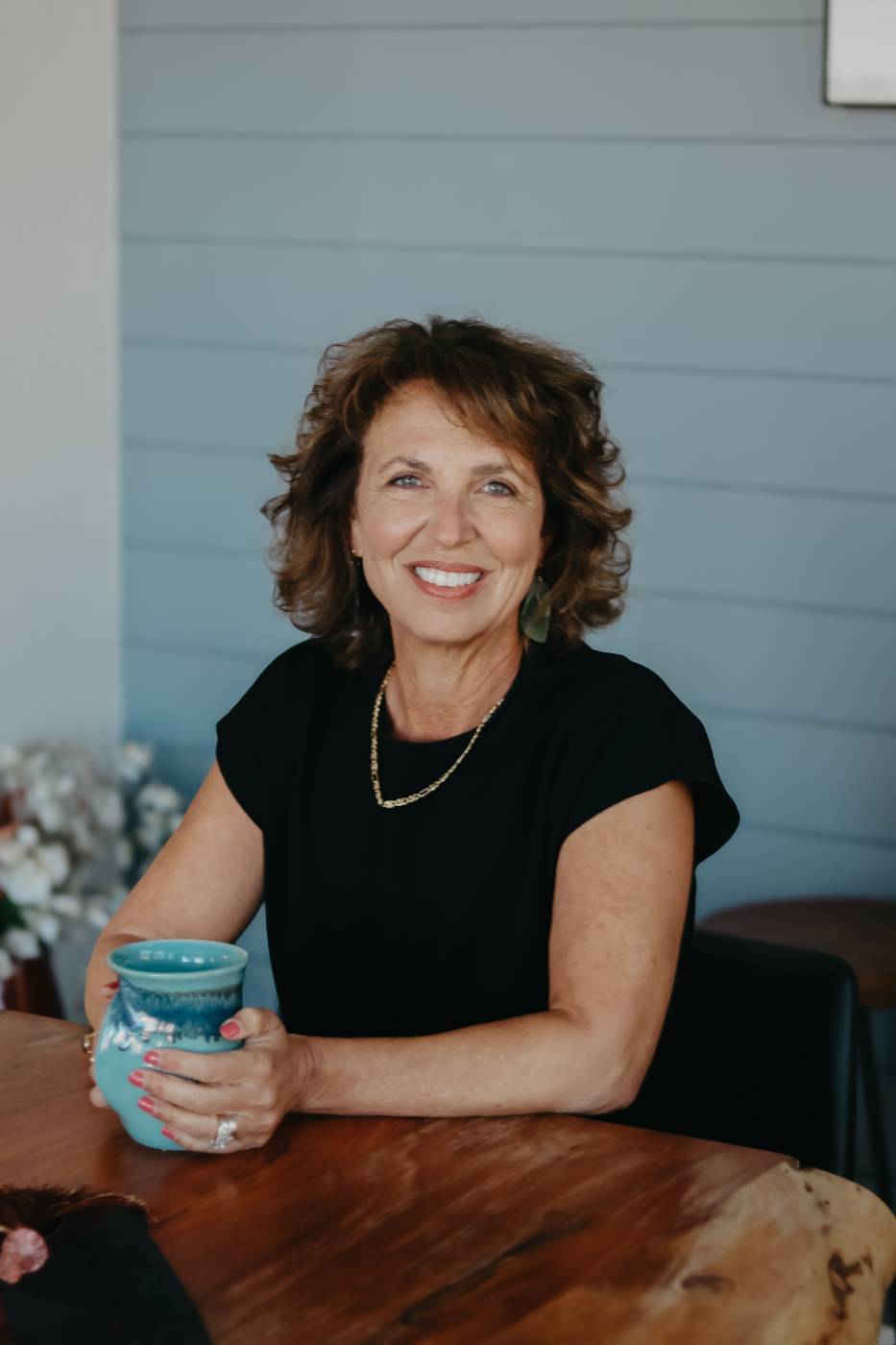 Marietta Zygaj smiling at a table with a turquoise mug